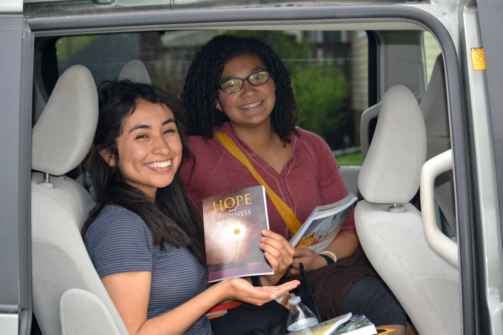 Two people smiling holding a book