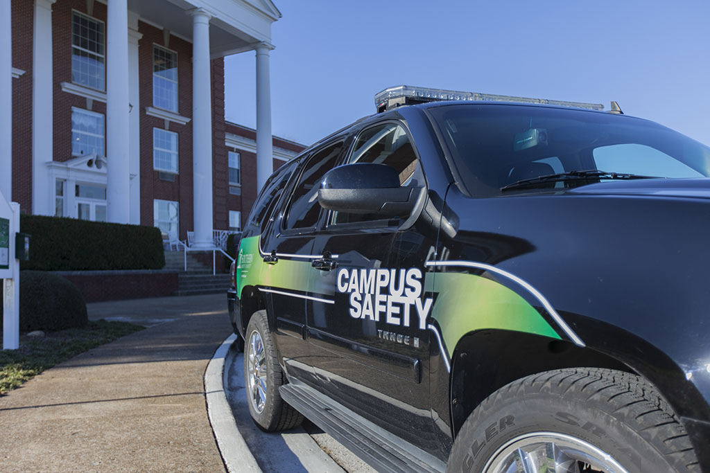 A side view of a Campus Safety patrol vehicle parked in front of Wright Hall