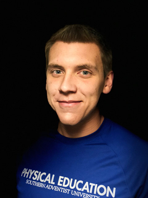portrait of young man wearing a blue shirt in a black background