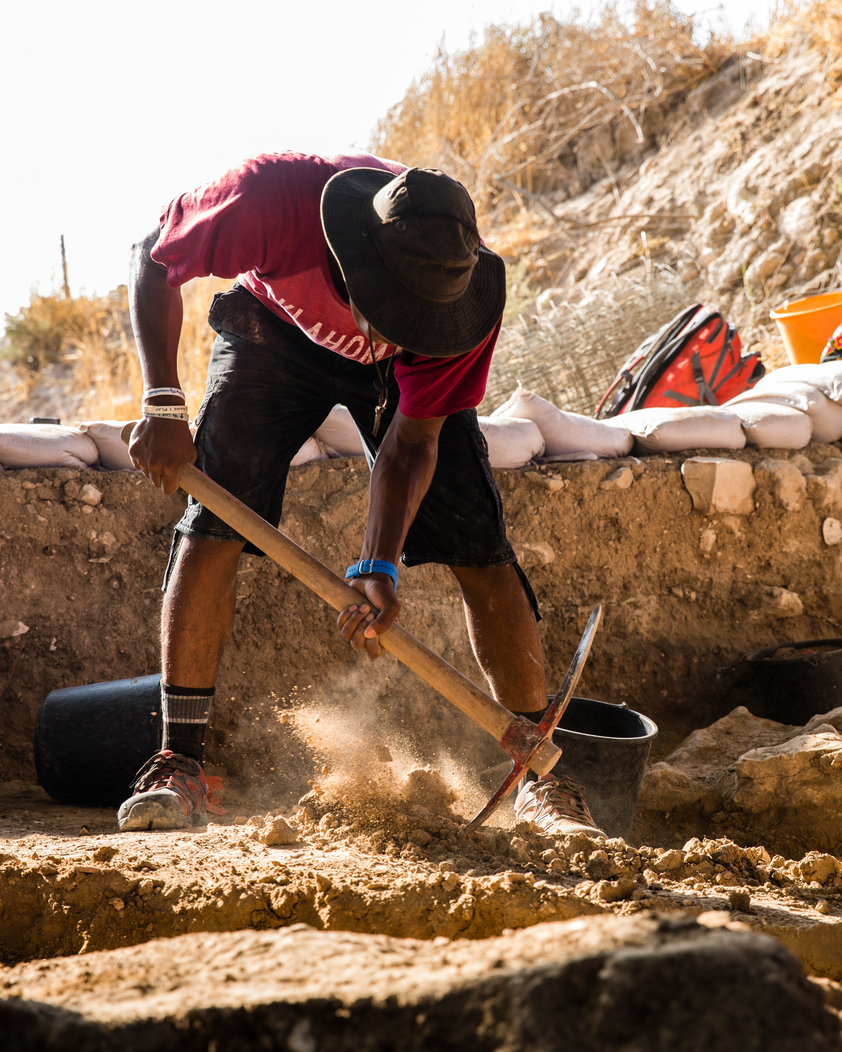Student excavating with a pickaxe