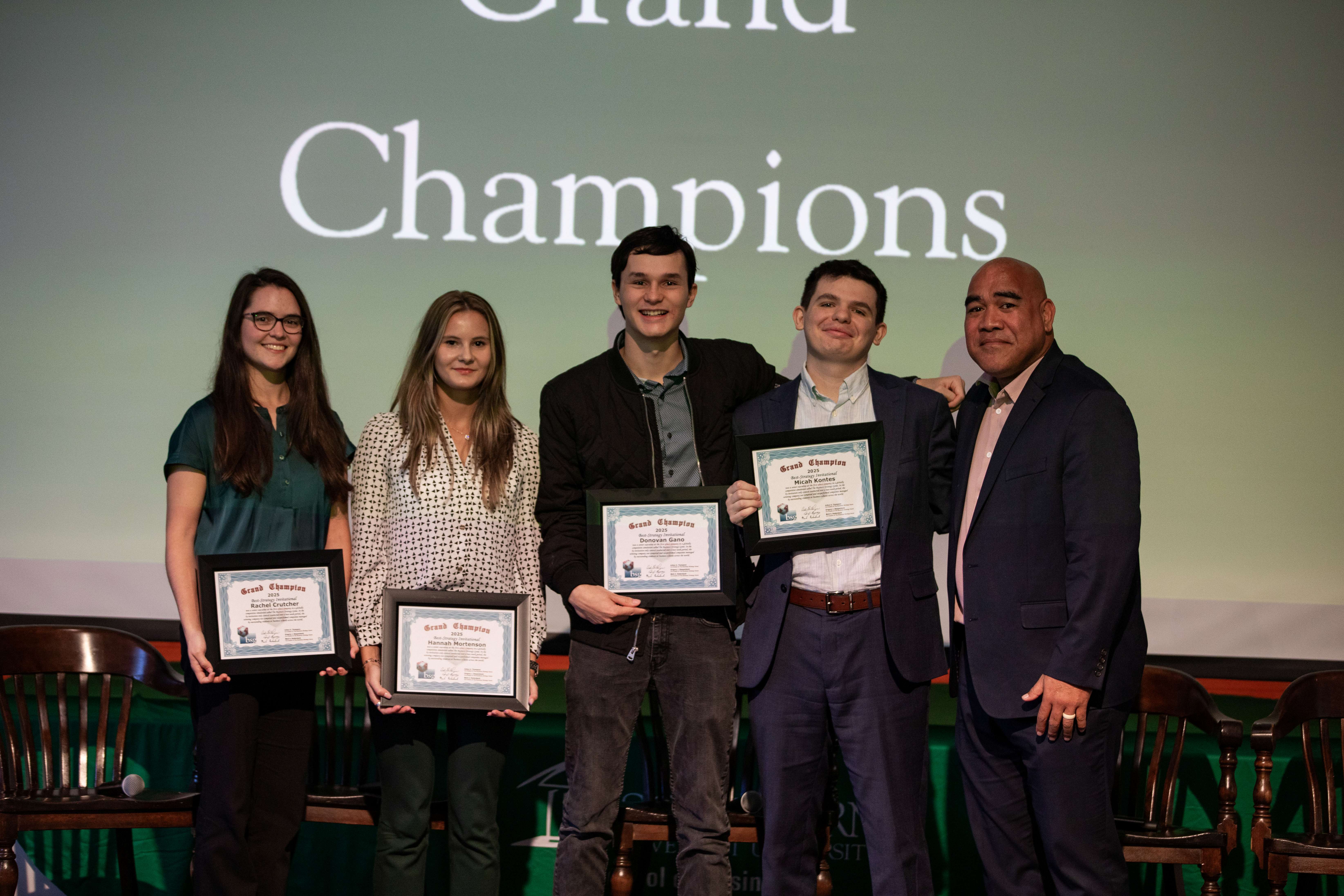 three people smiling, holding an award