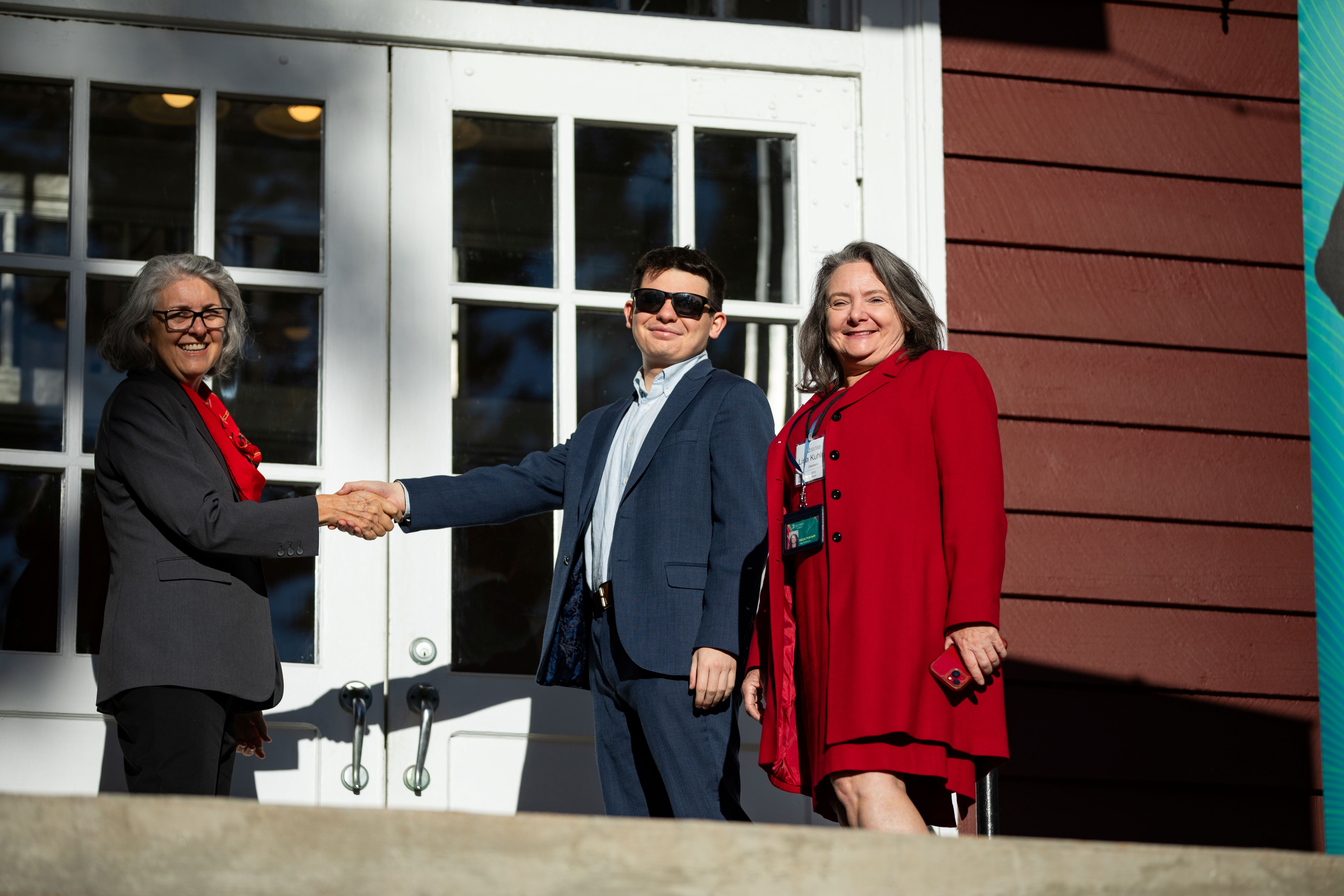 Three people smiling for an award