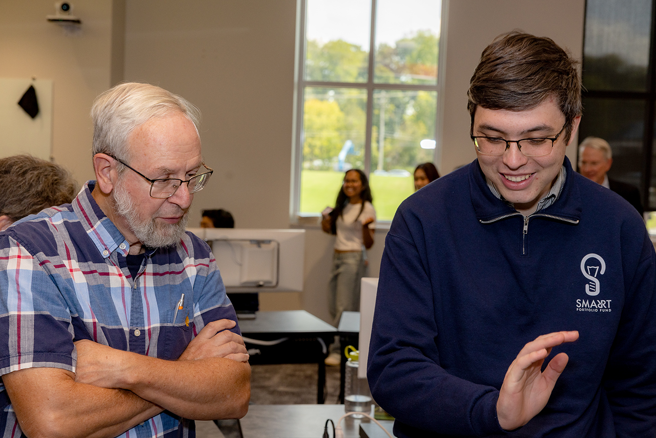 Students demonstrate the financial lab for guests at the Ruth McKee School of Business grand opening.