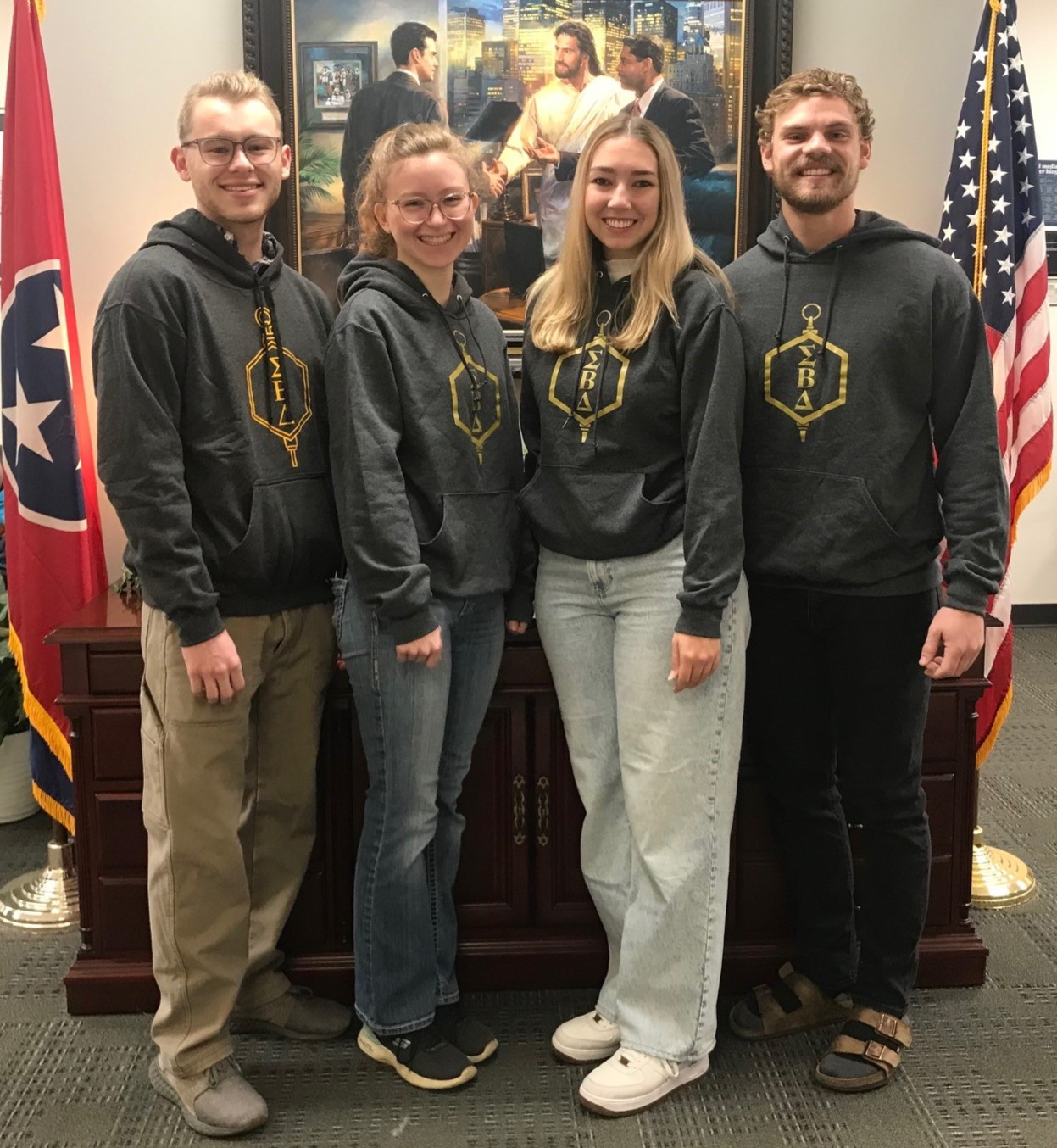Four students wearing Sigma Beta Delta Sweatshirts