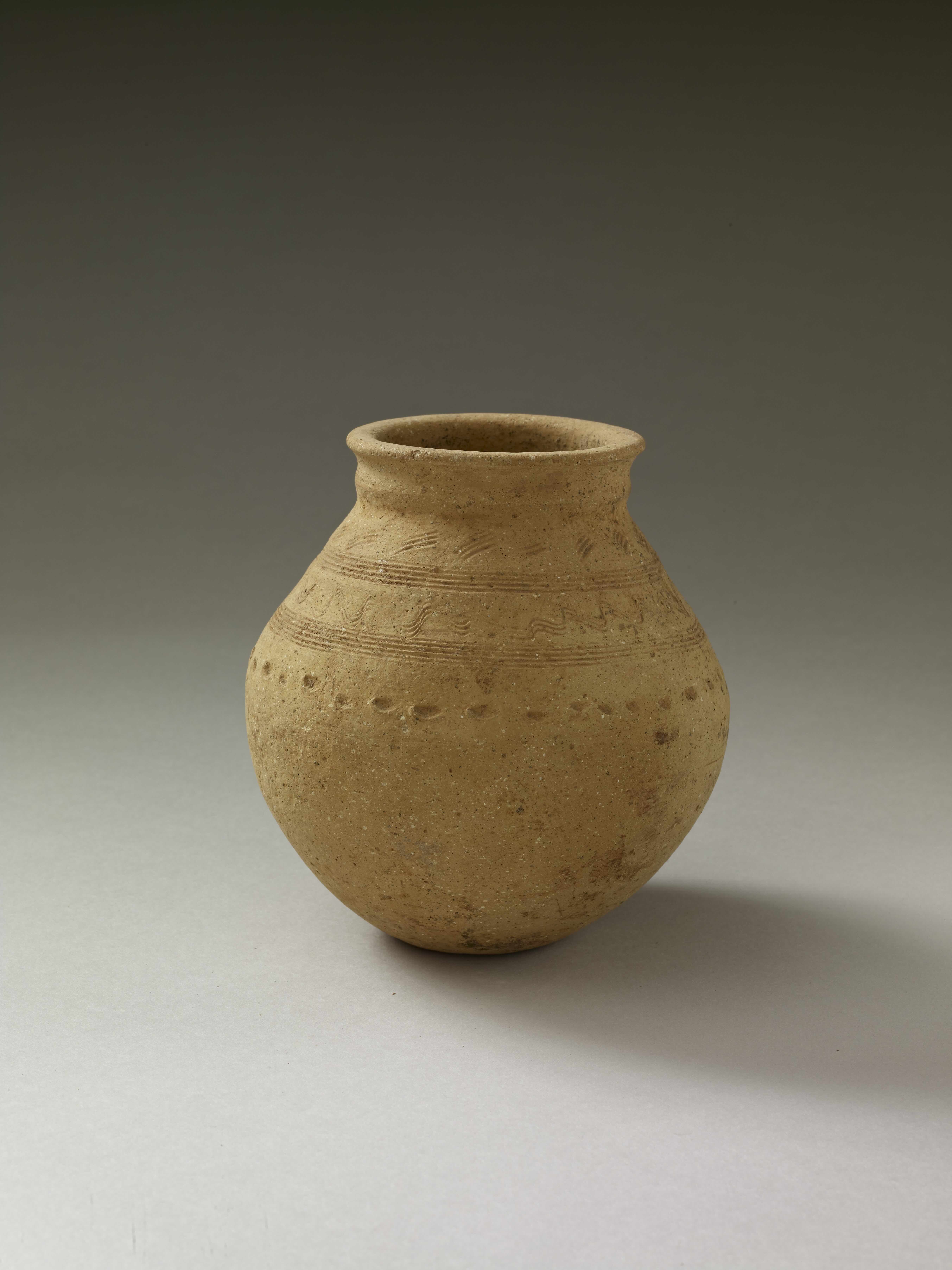 a yellow jar with decorative holes drilled in its side