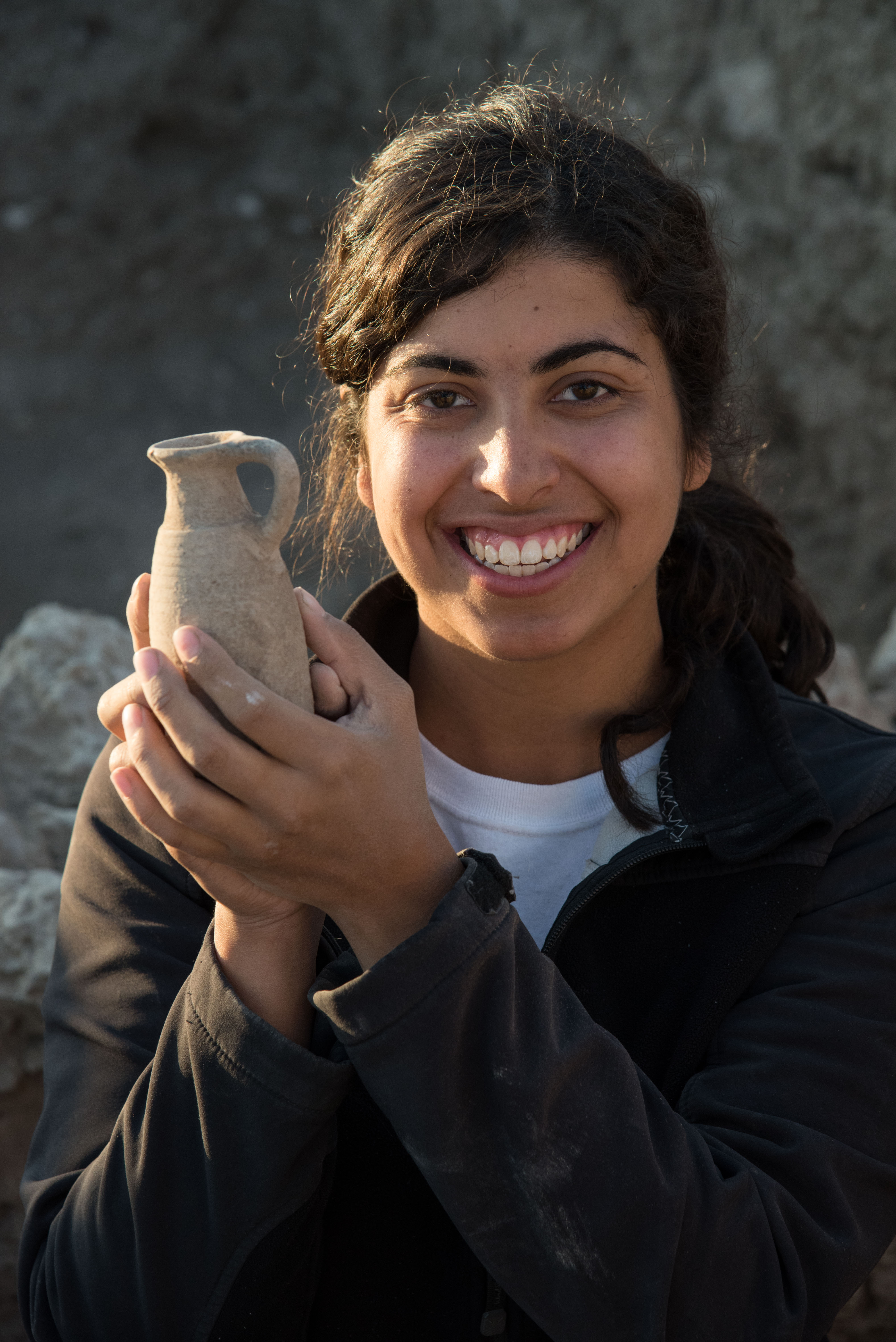 someone holding a clay vase