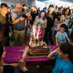 People surrounded by a birthday cake