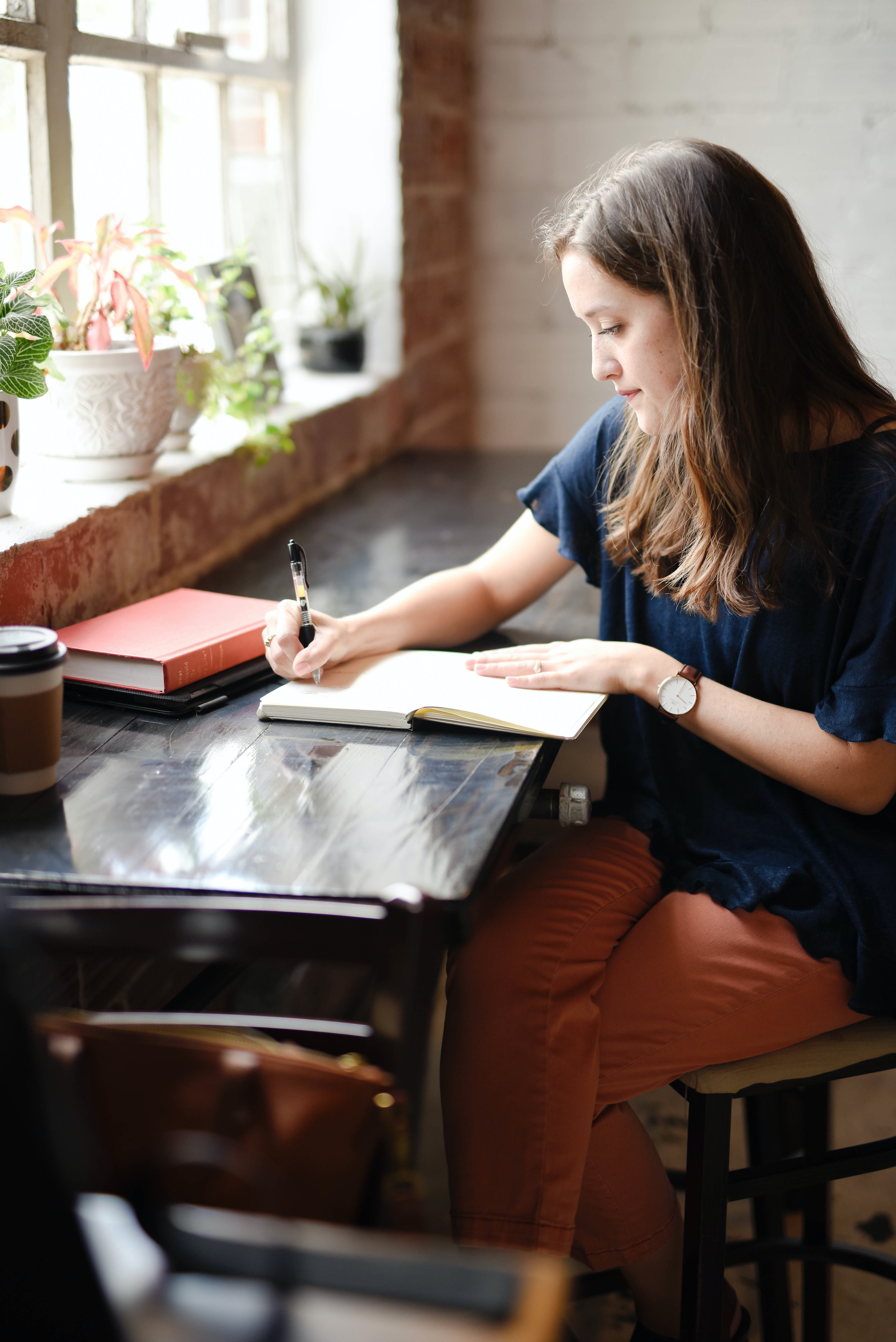 Woman reading and journaling at a desk