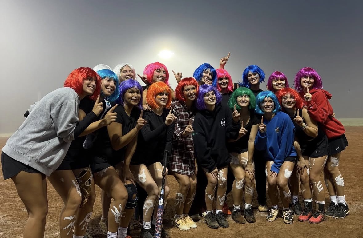 Bat Biddies posing on a softball field after winning the championship