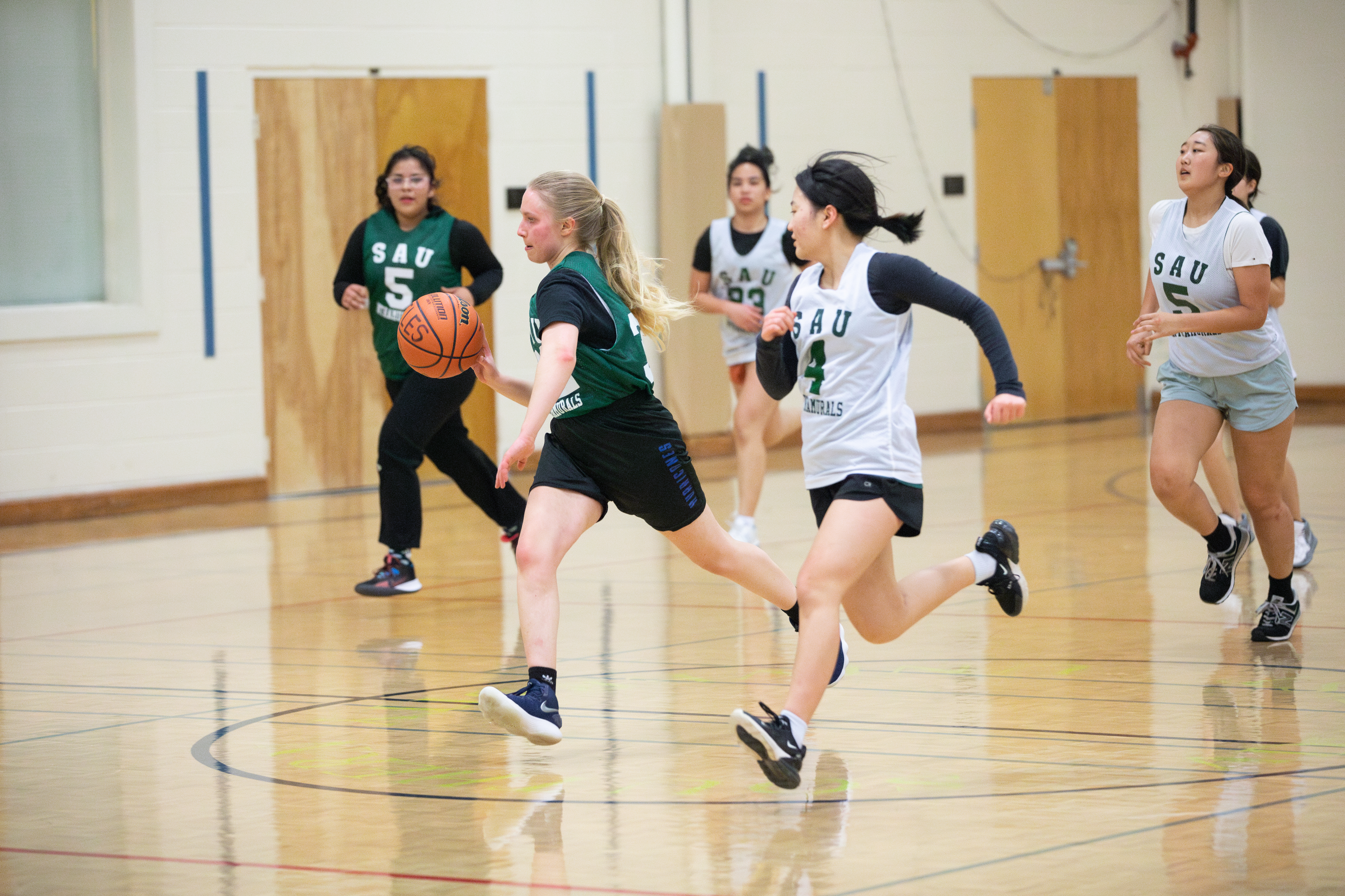 Female basketball players running on the court