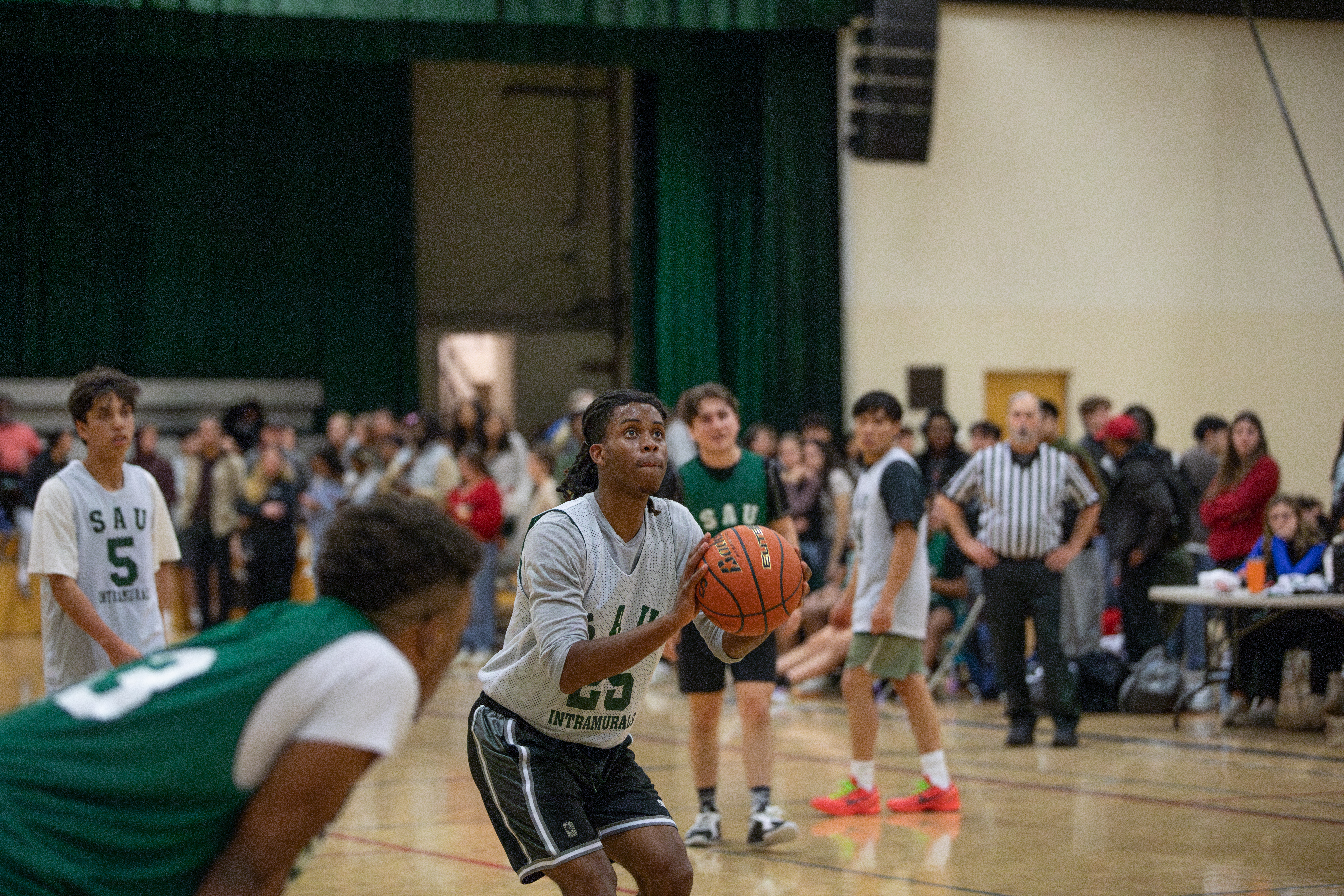 A male basketball player attemps to shoot a free throw