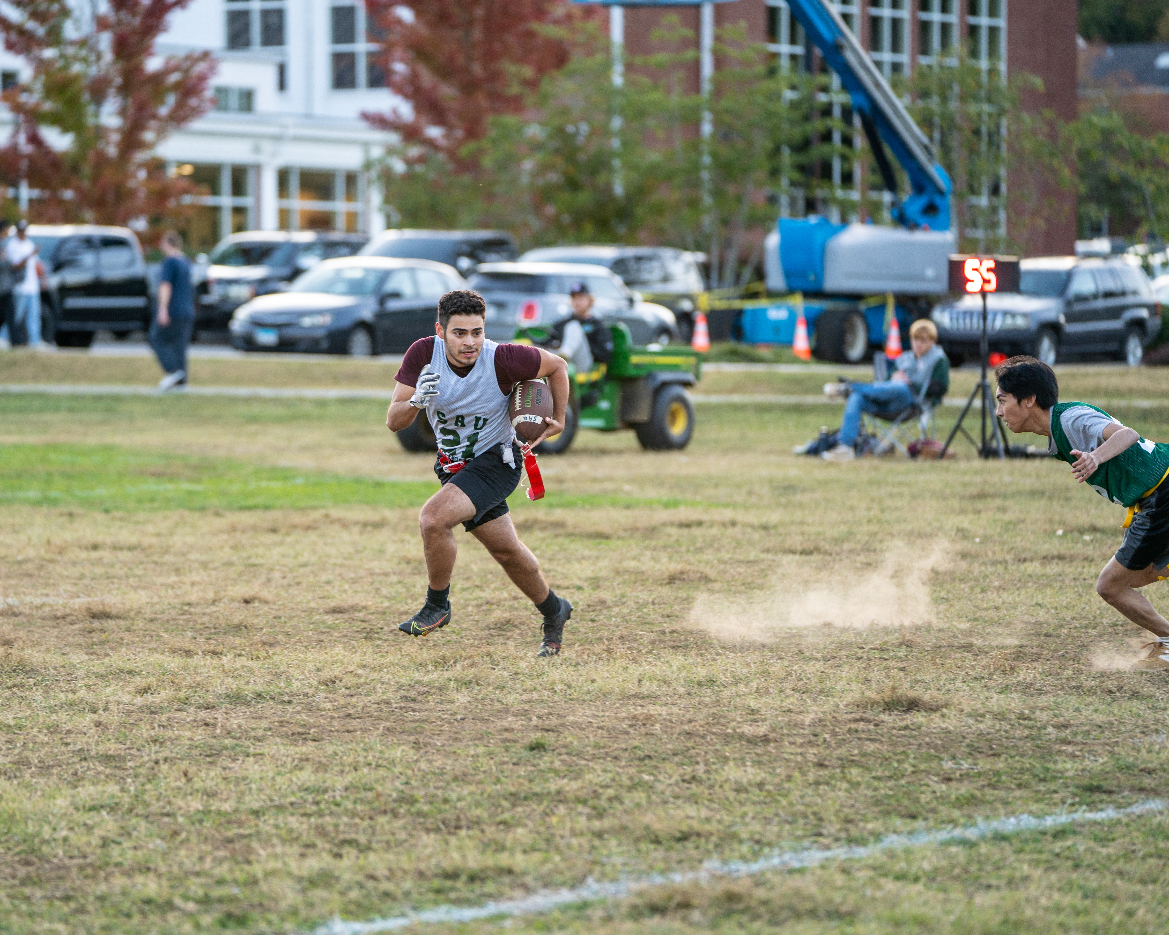 A quarterback running with the ball in front of a defender