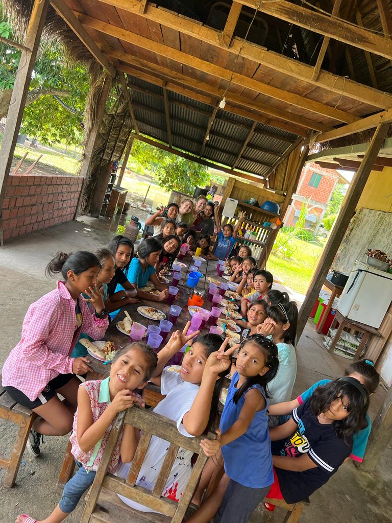 Kids at Familia Feliz sharing a meal together.