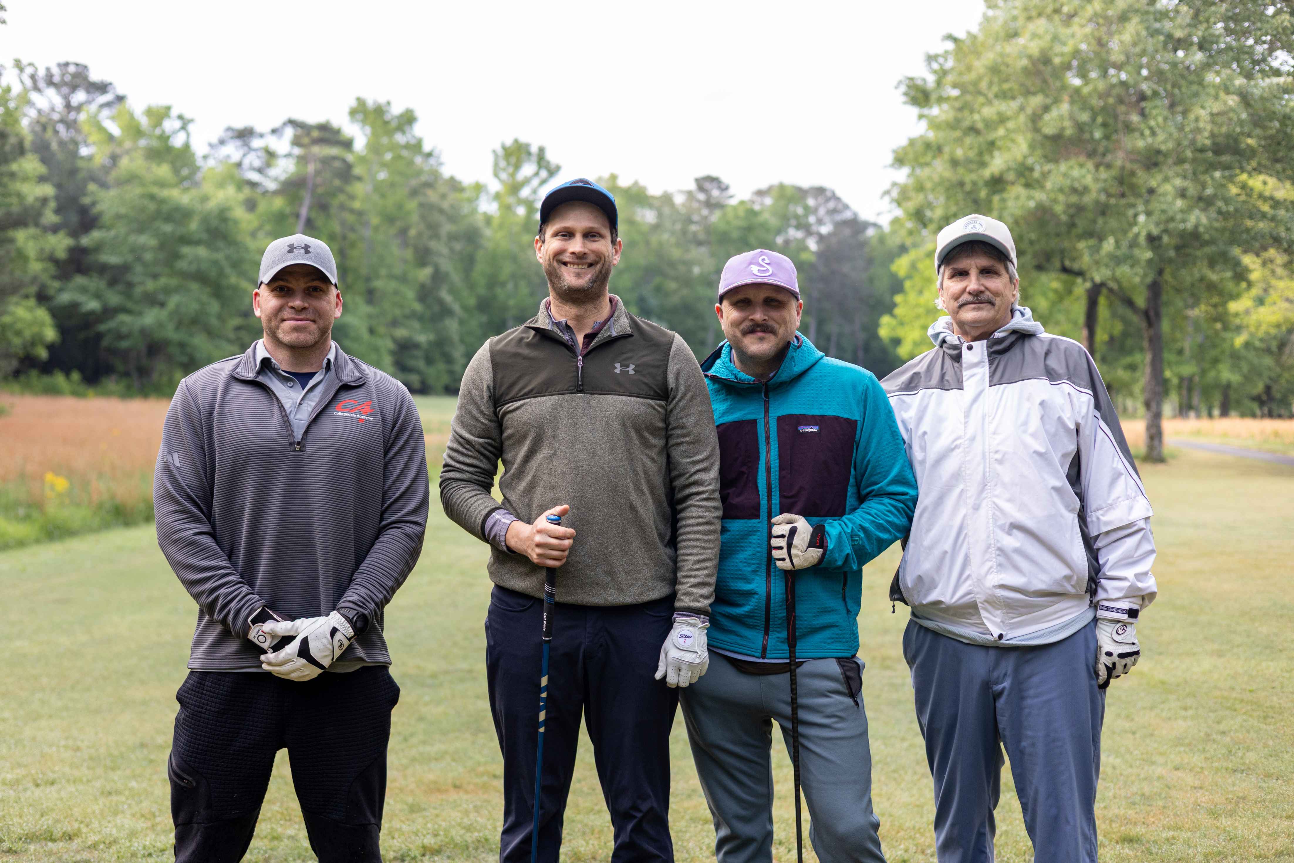 four golfers posing 
