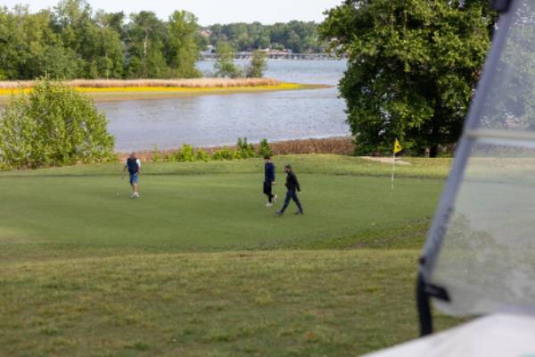 three people playing golf