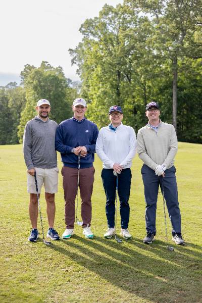 Four golfers standing together on the green