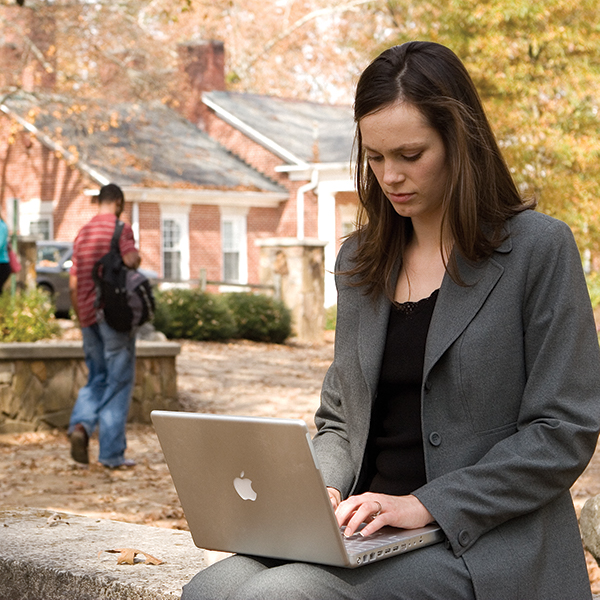 Young lady using laptop outdoors