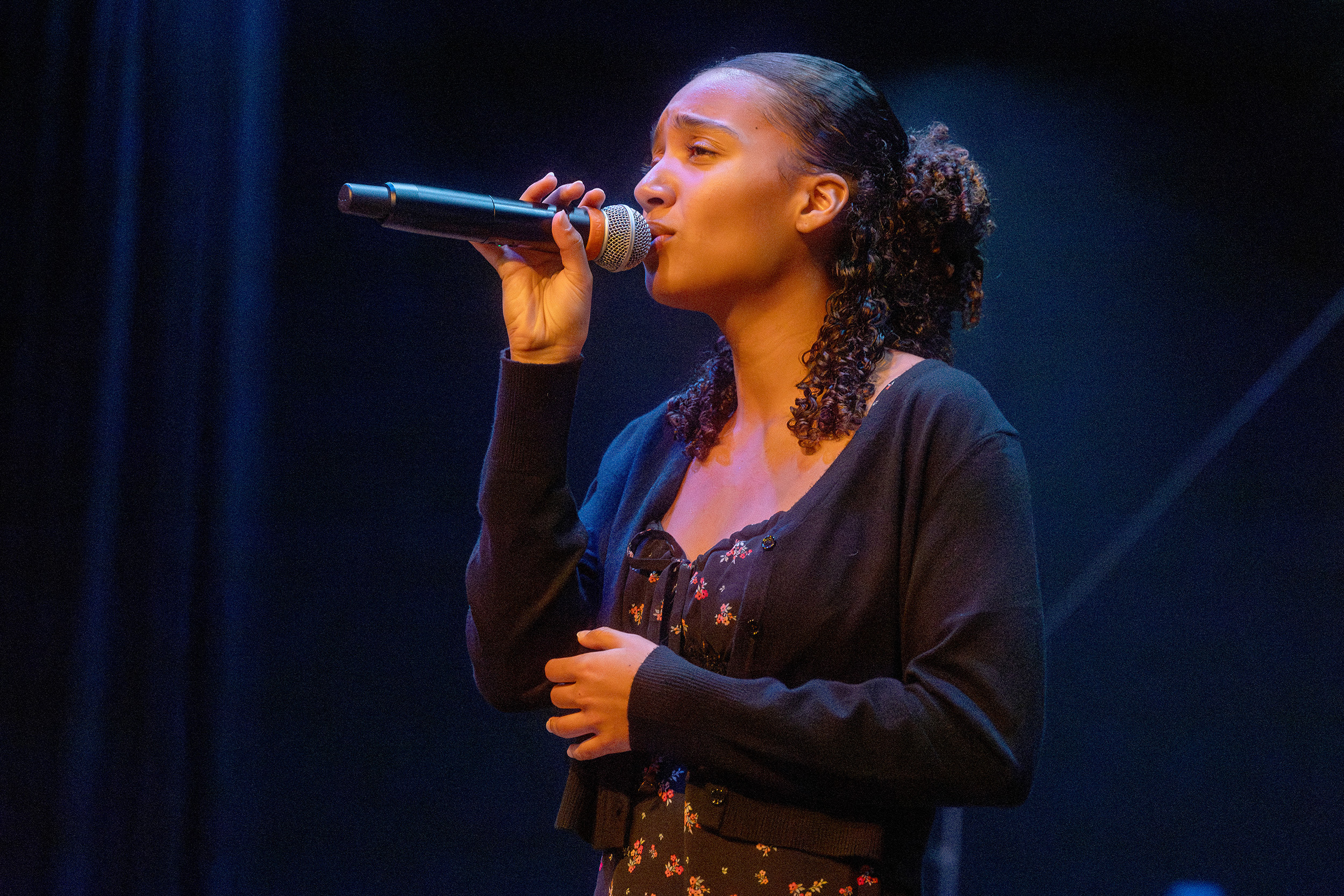 a girl sings into a microphone
