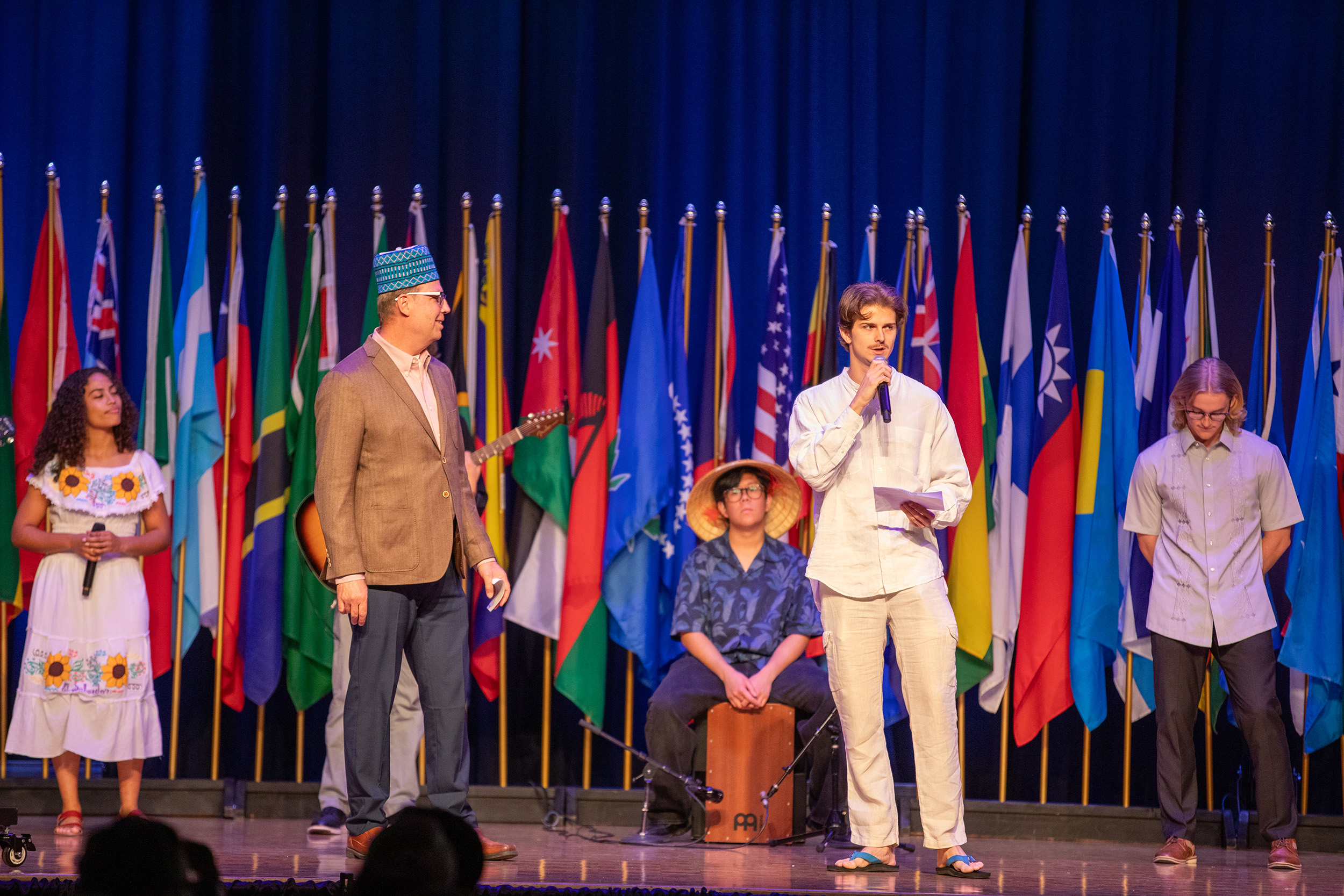 student missionaries on stage with international flags 