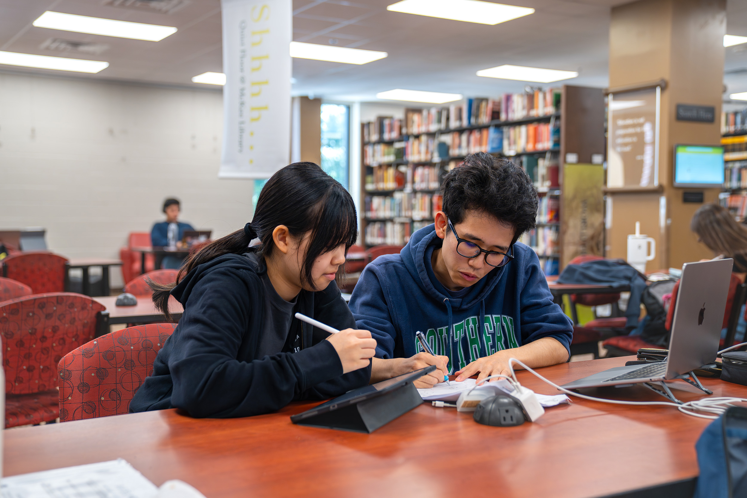 two students study in the library