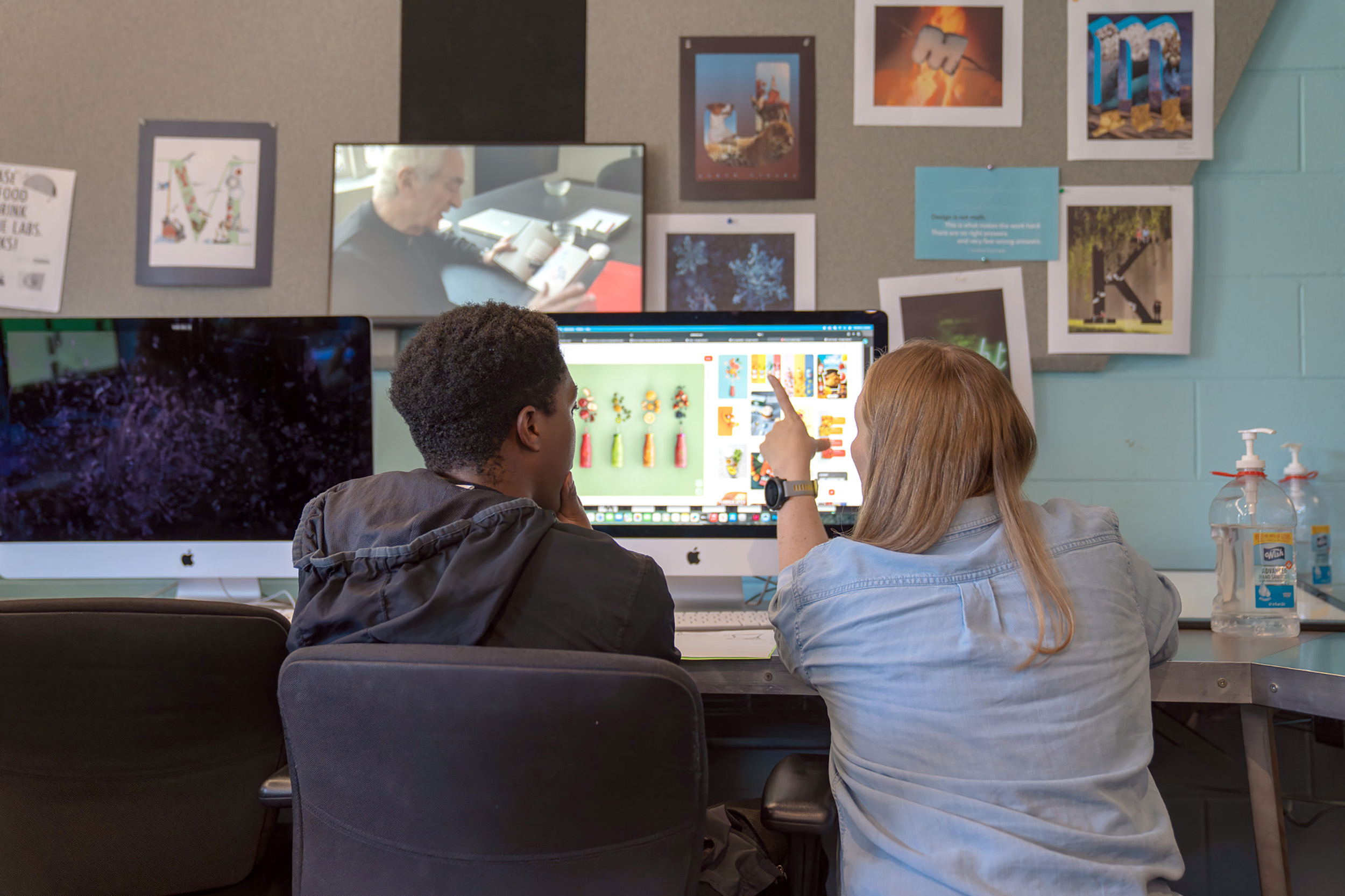 a professor and student look at a computer screen