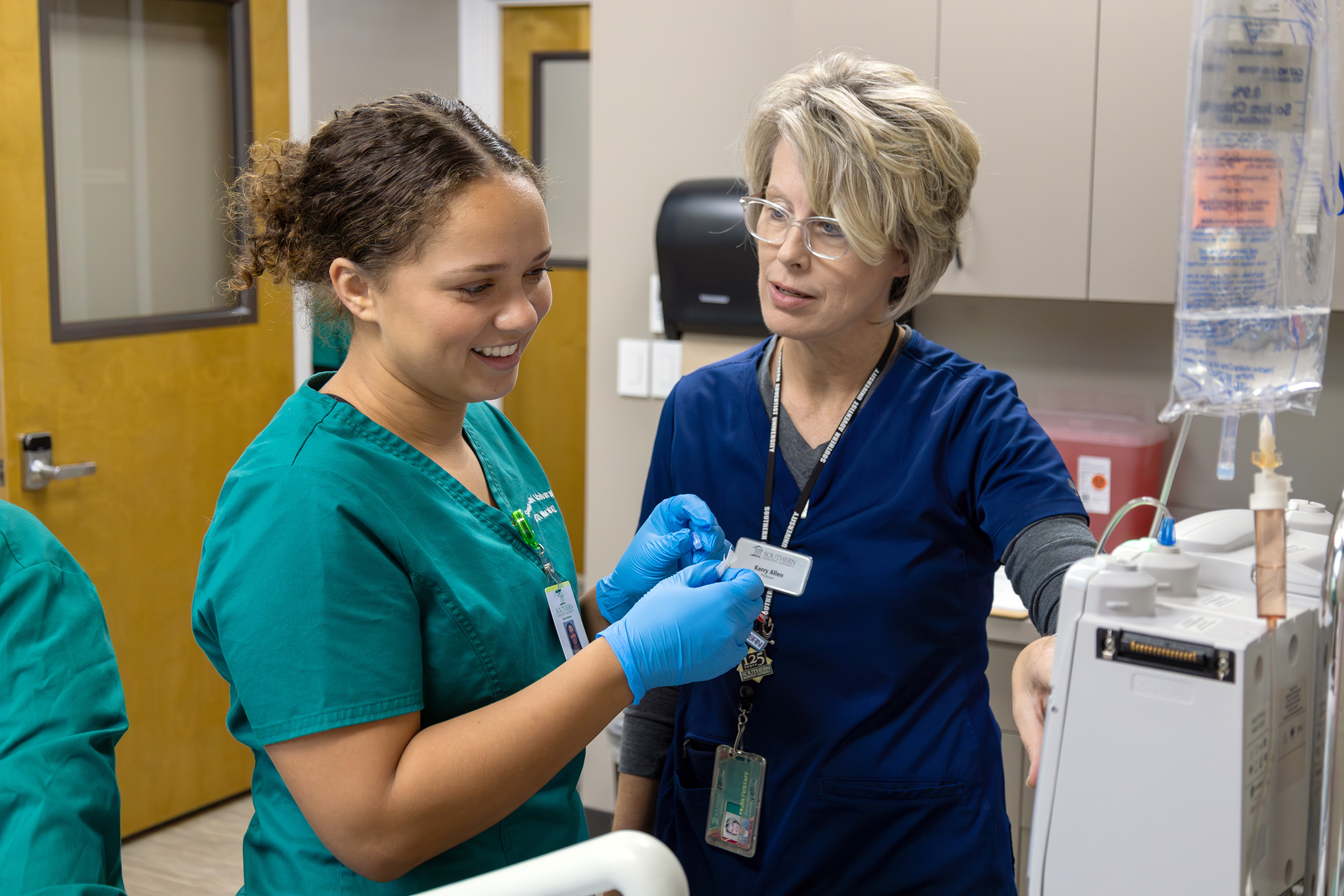 a nursing student and professor work in the simulation lab