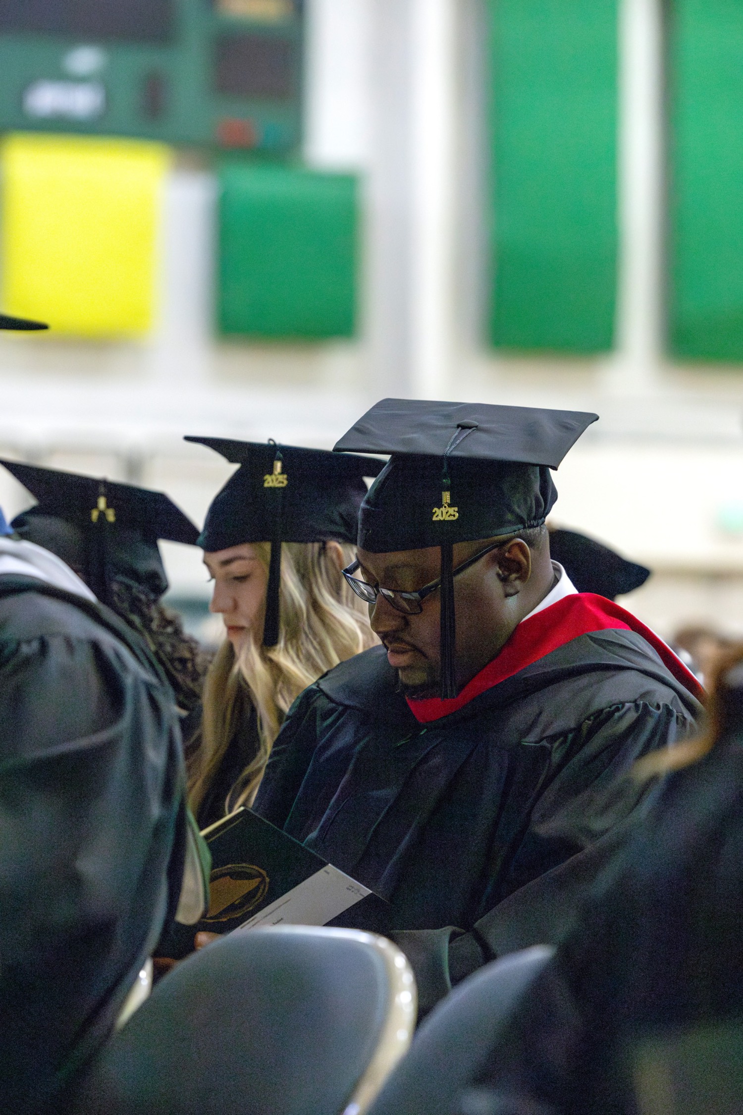 students sit contemplatively at graduation