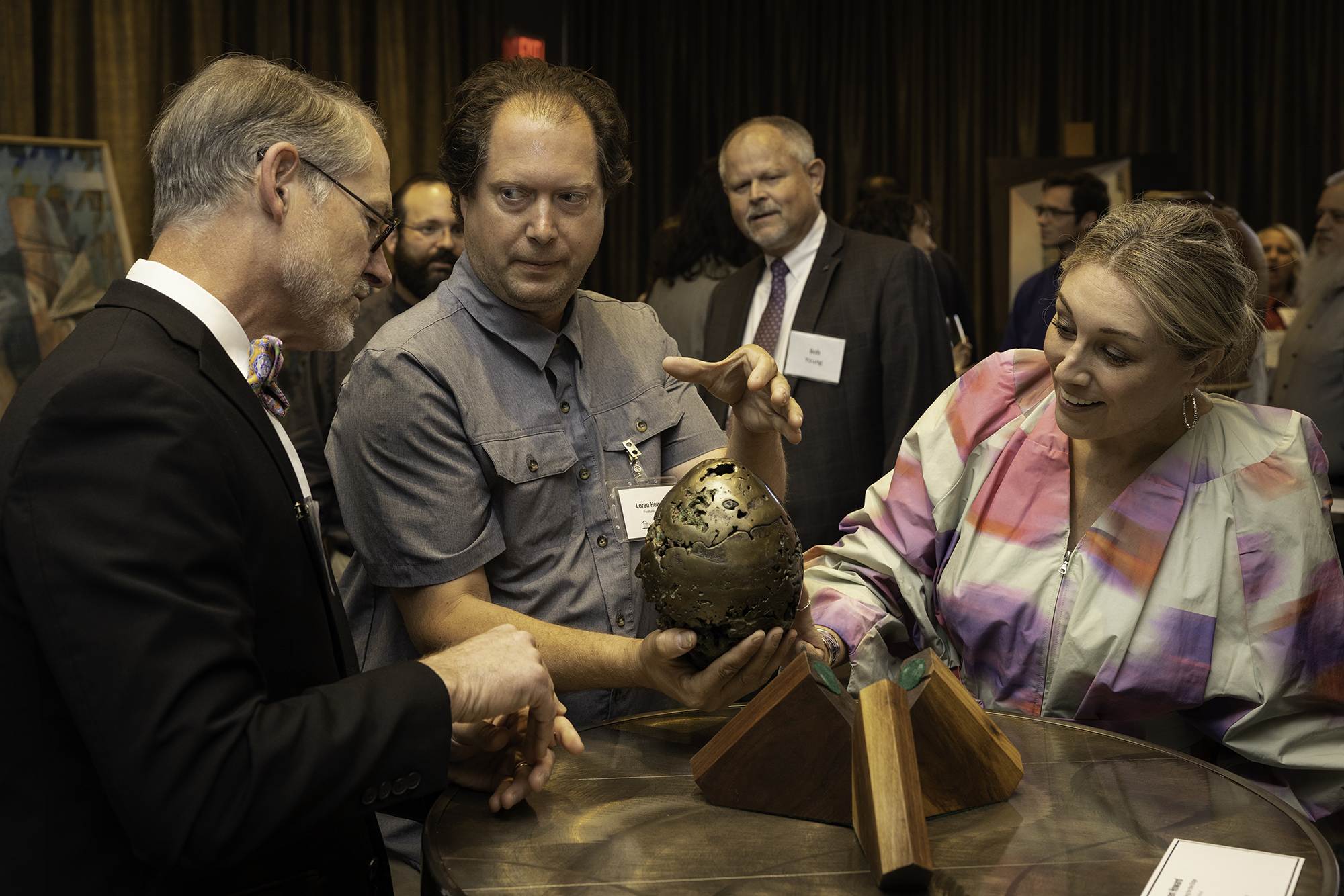 three people looking at an object