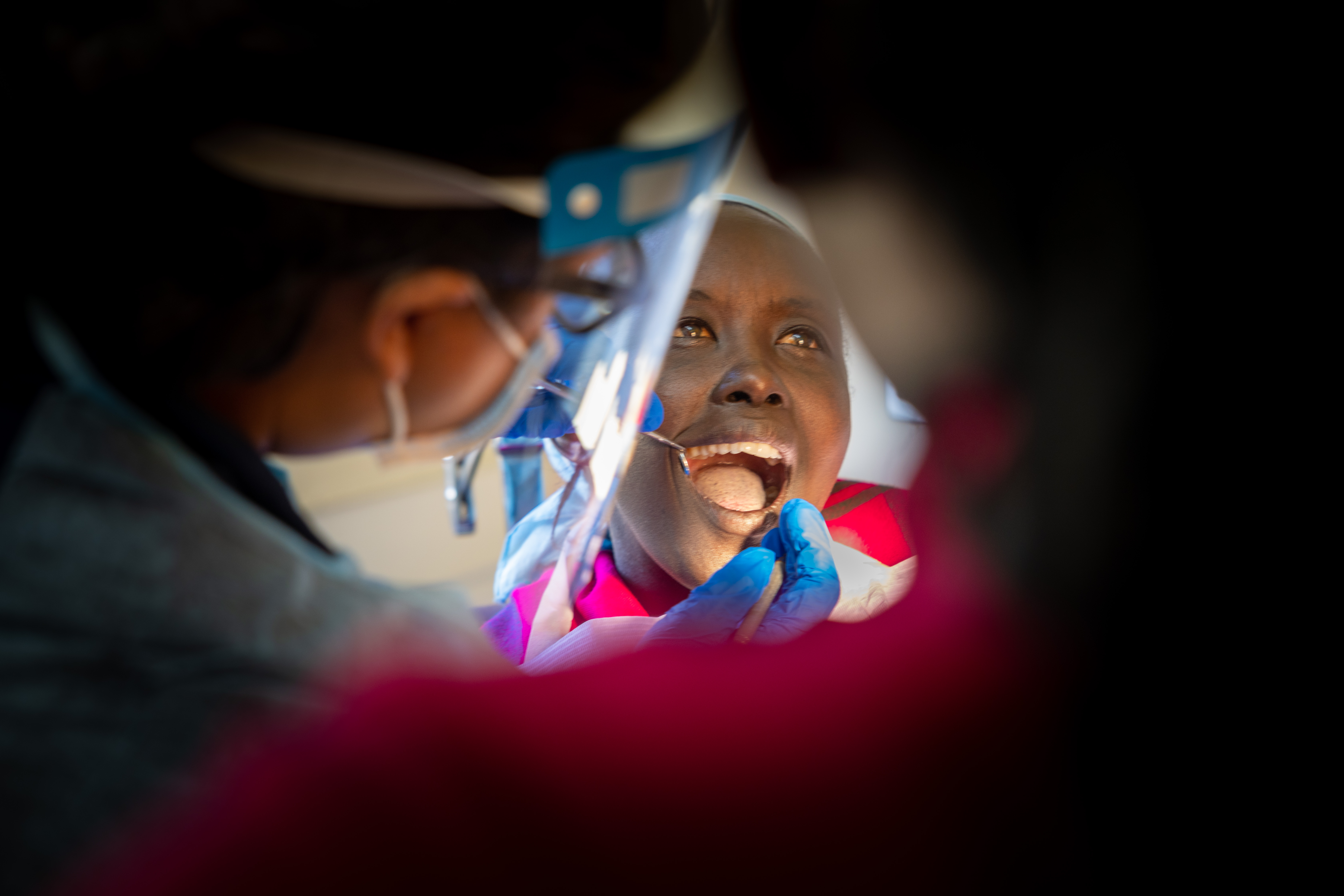 Medical personnel inspect a person's teeth