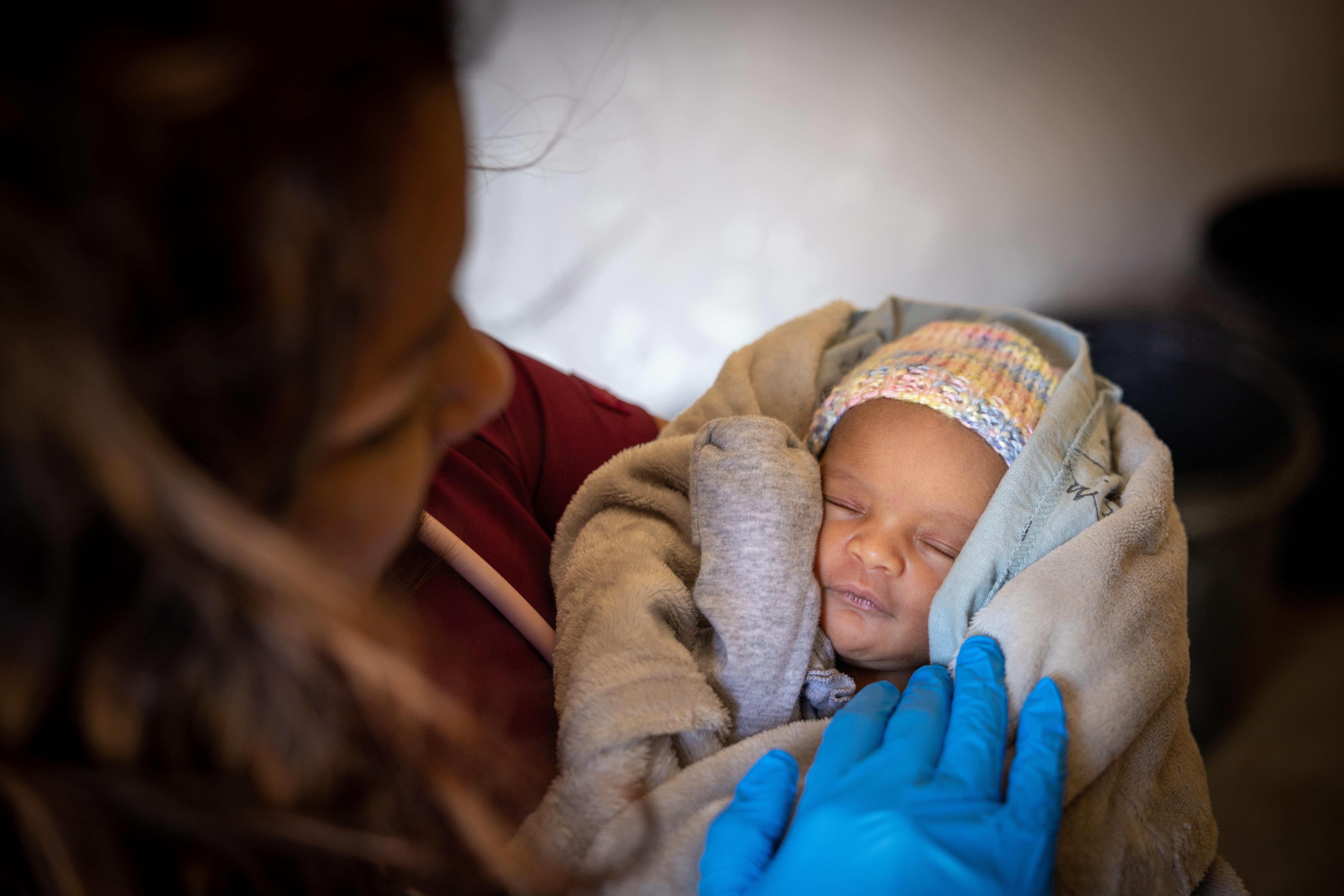 Medical personnel holds a newborn baby