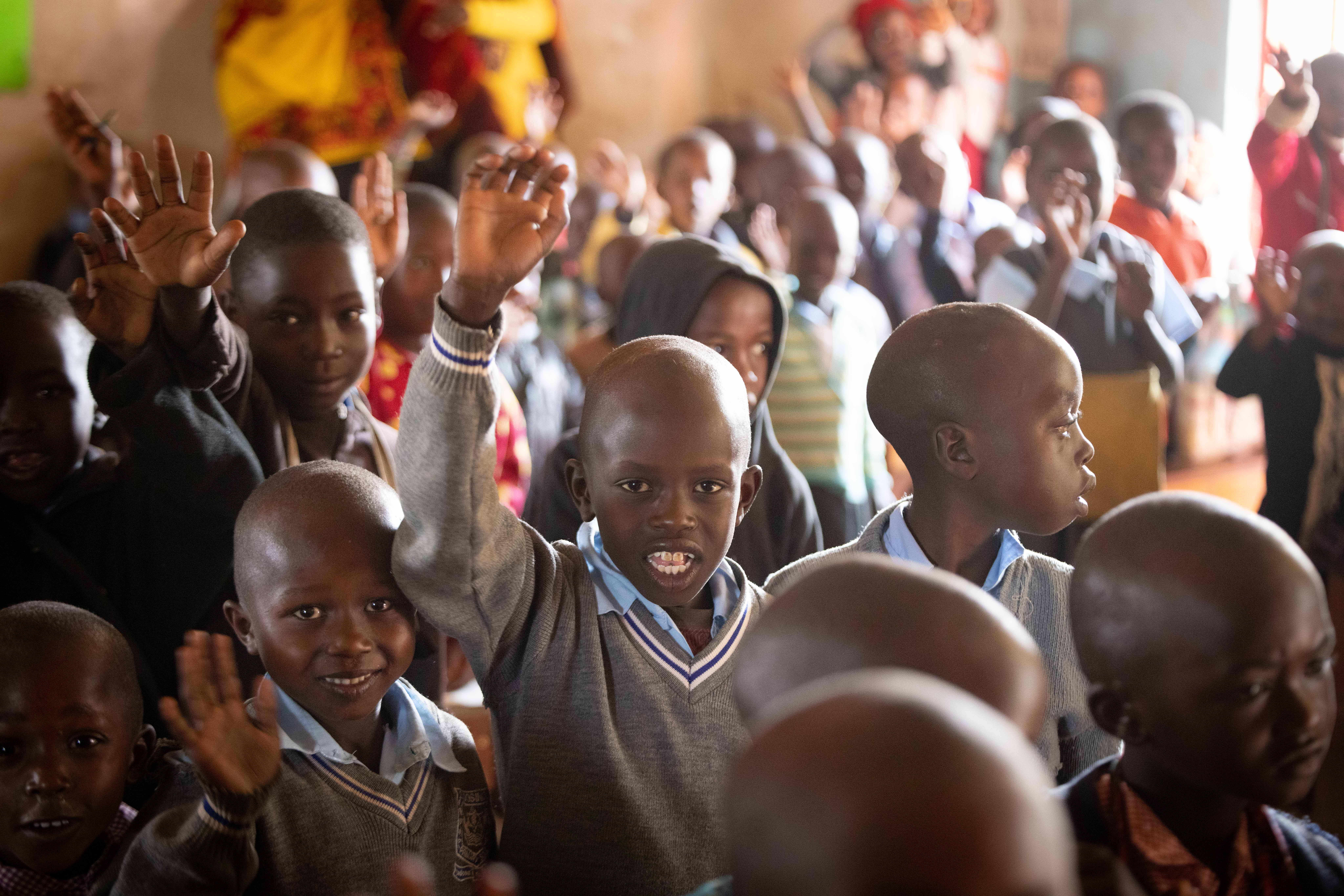 Kenyan primary school students wave hello