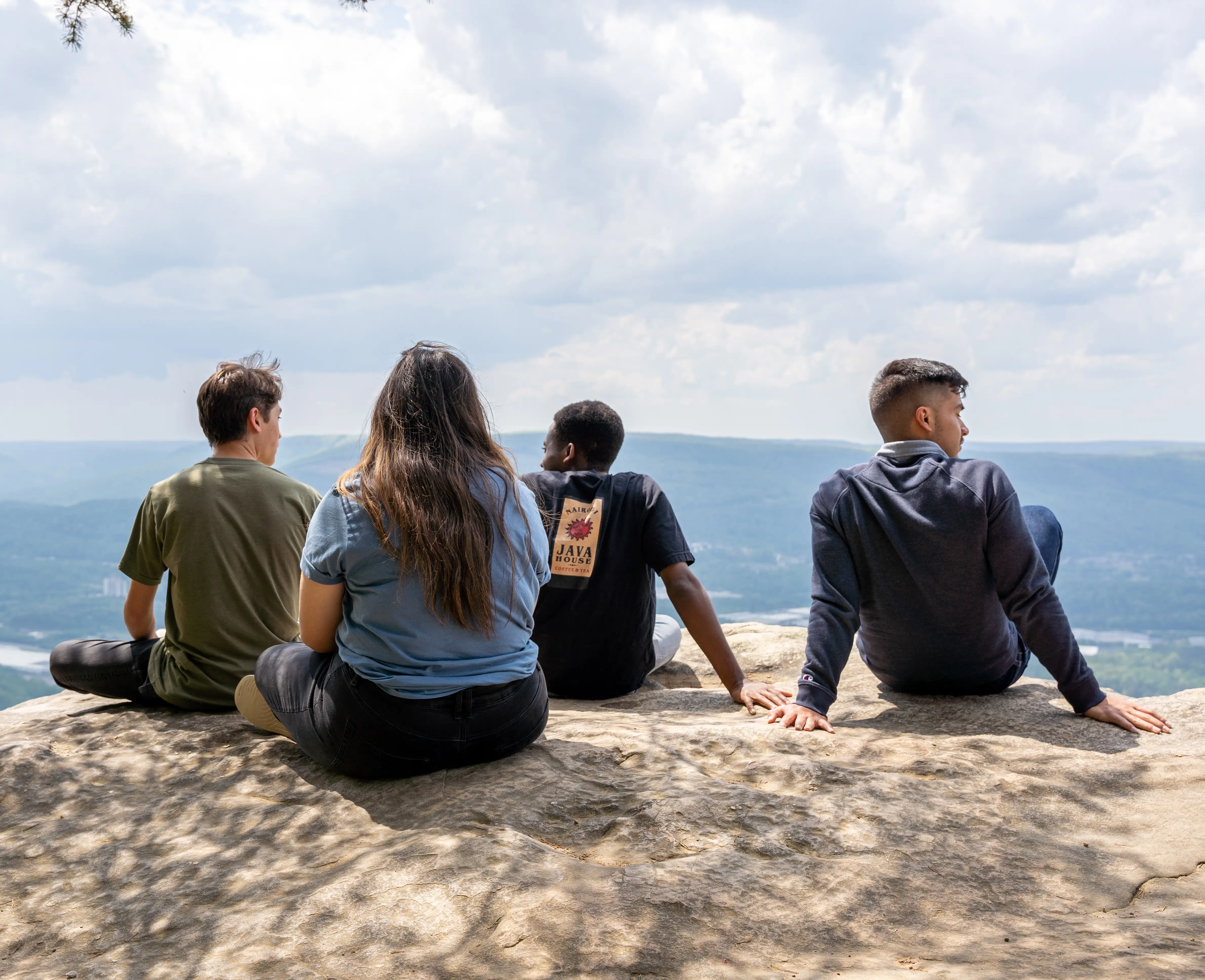 Four Southern students sit on a rock overlooking Chattanooga.