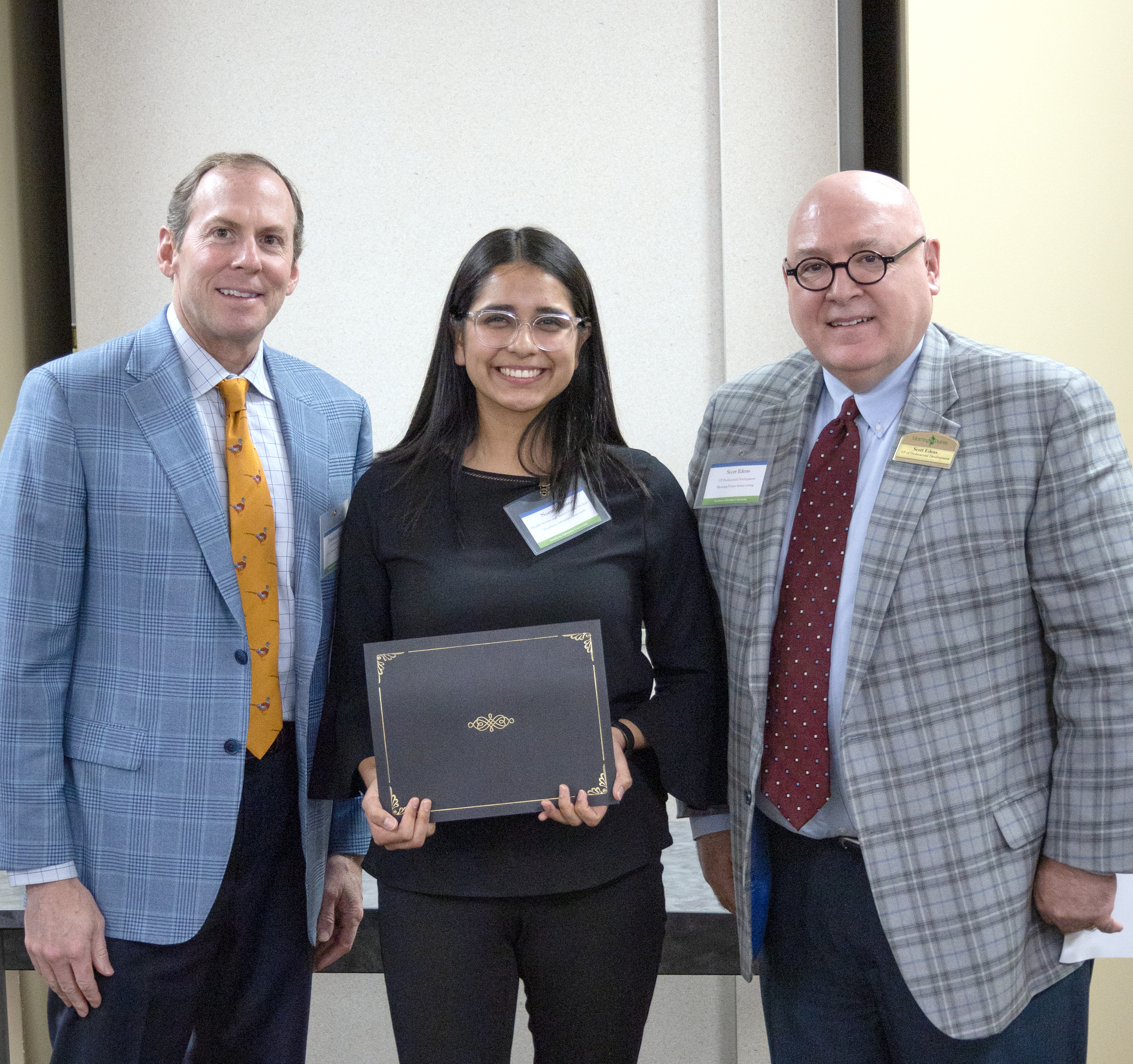 Noemi Lozano is presented with the scholarship by Franklin Farrow and Scott Edens of Morning Pointe.