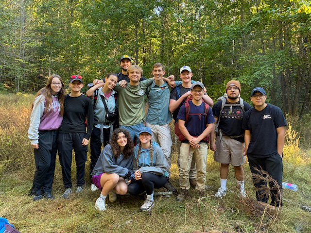 students pose for a group photo on a backpacking trip