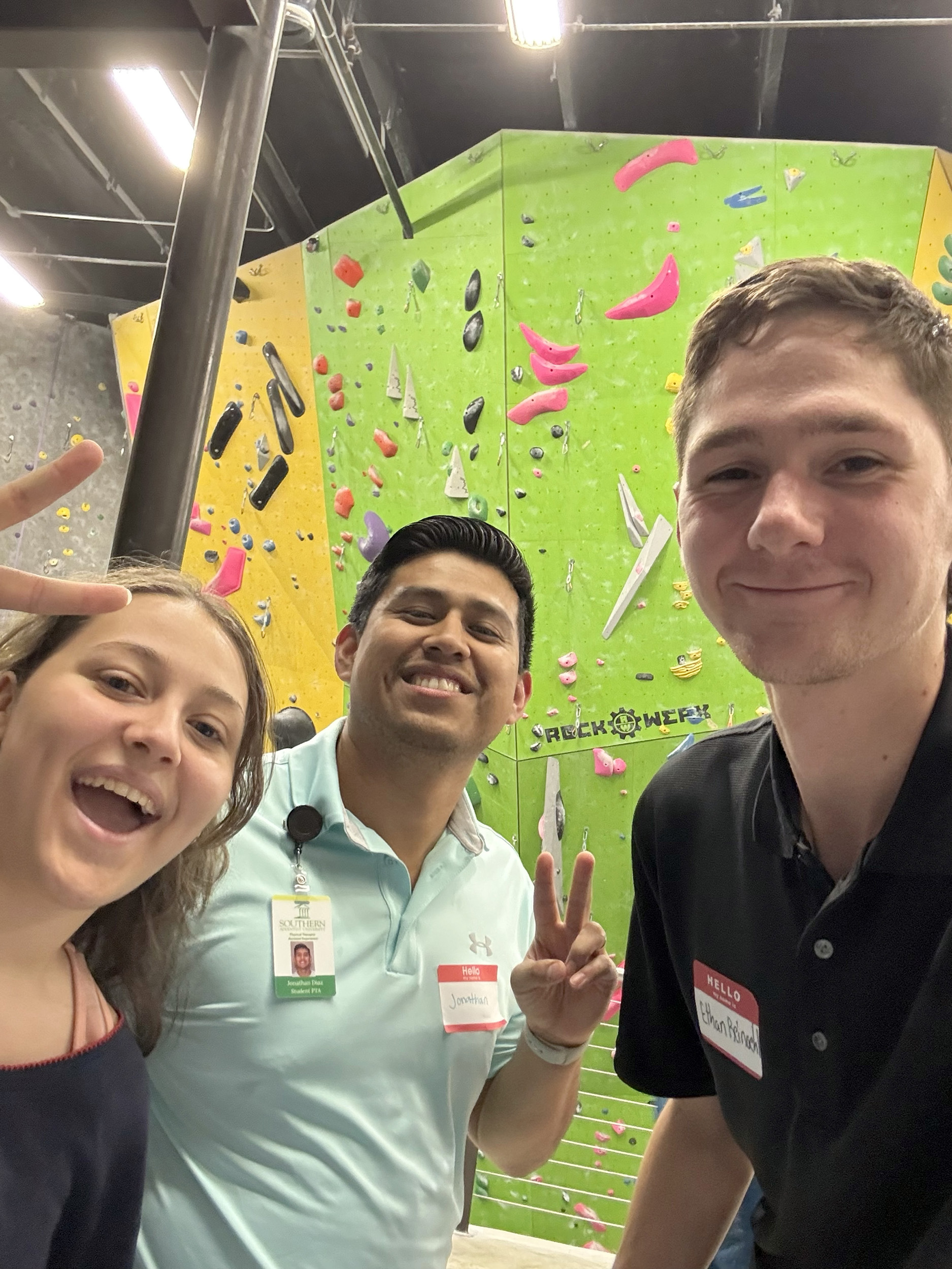 students in front of a climbing wall