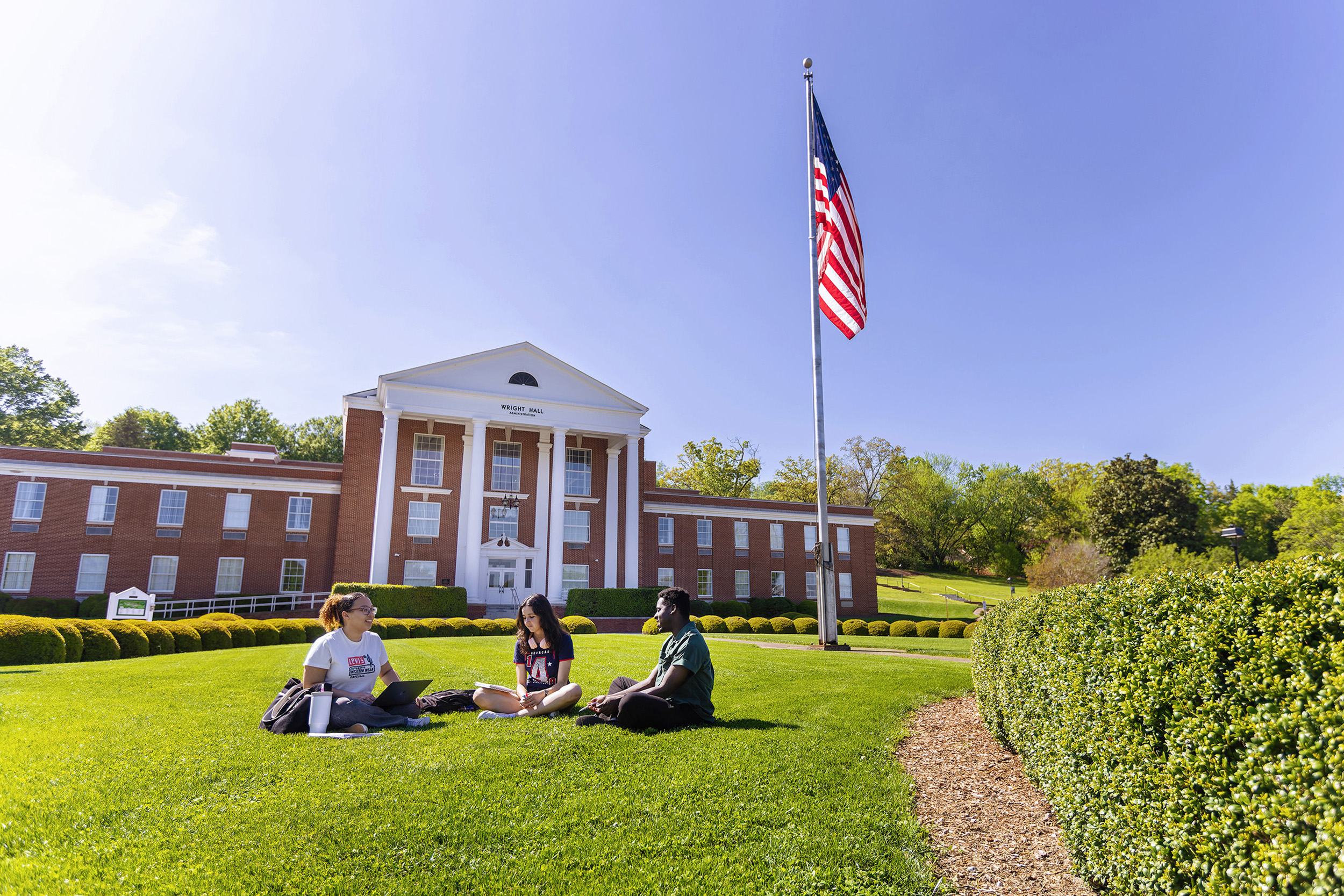 students talk on the lawn
