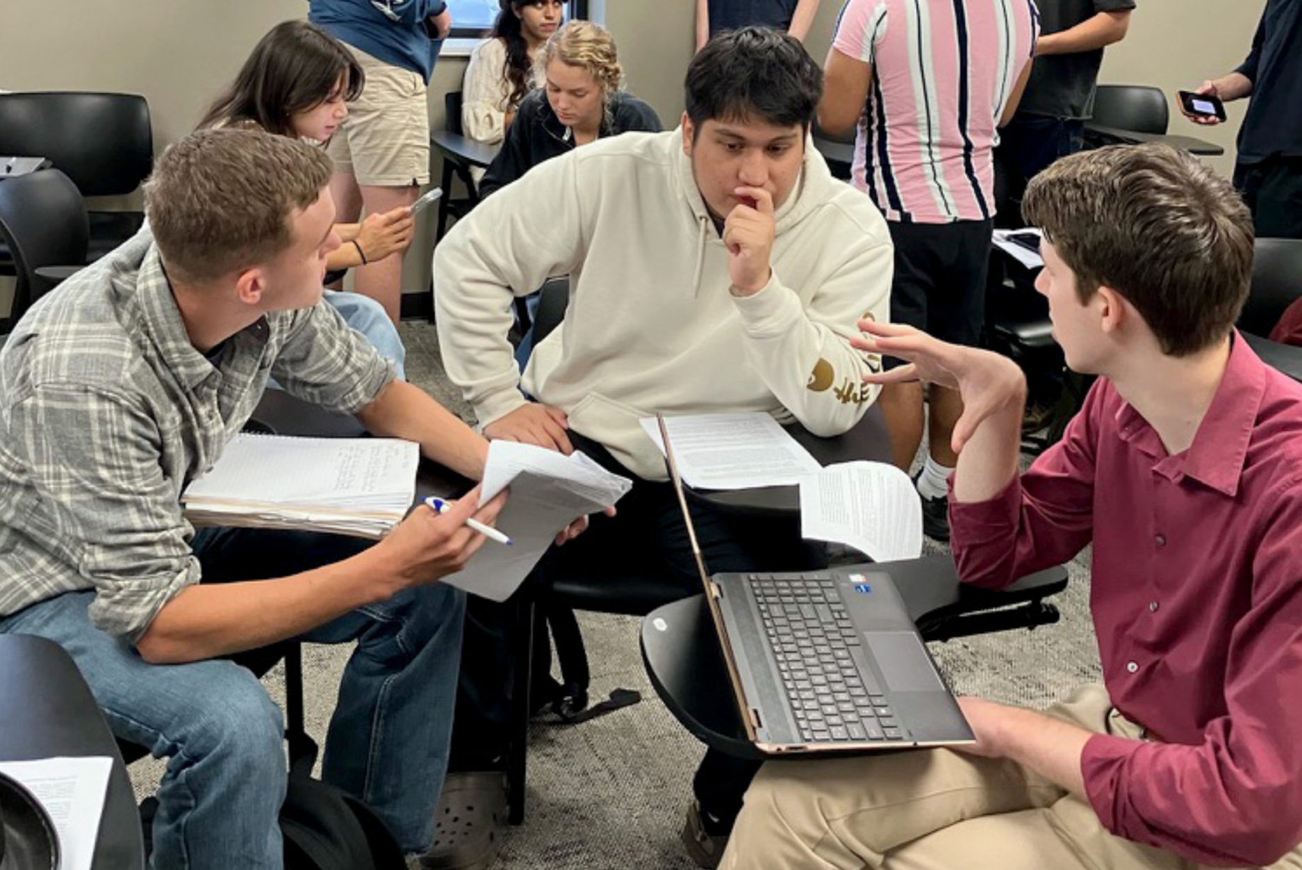 Group of students sitting at their desks in a class discussion.