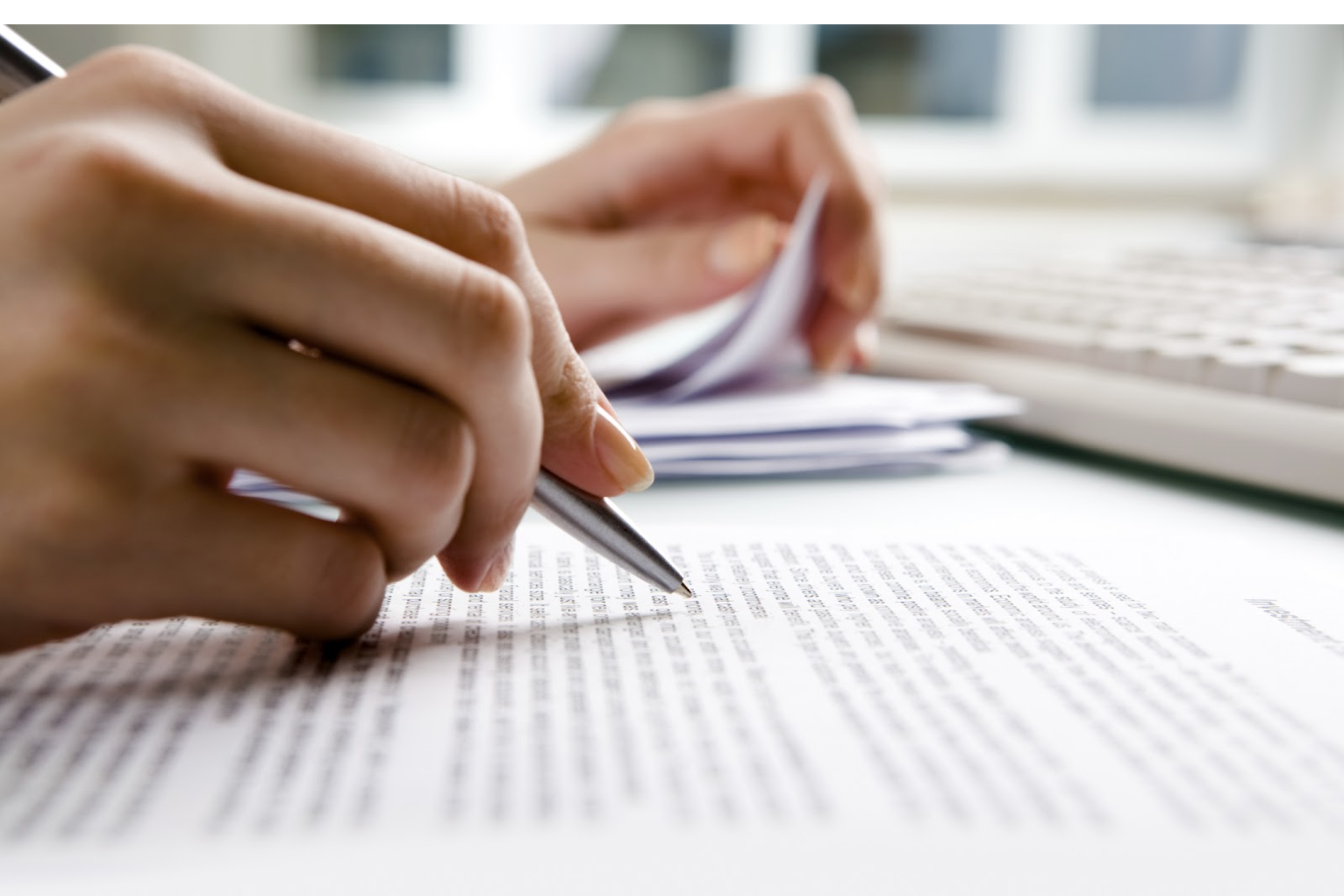 Close-up of a person writing on a document.